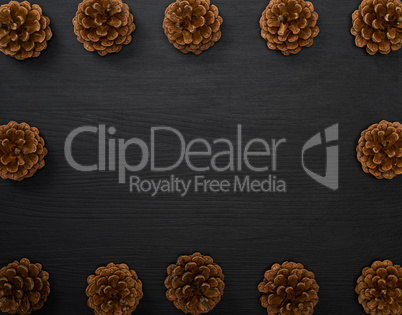 pine cones on a black wooden background