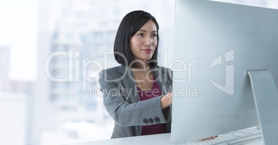 Businesswoman at desk with computer with bright background