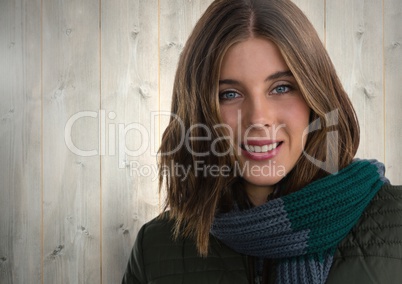 Woman against wood with warm scarf and coat