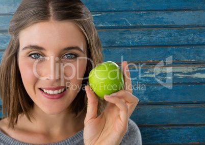 Woman against wood with apple