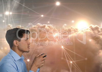 Businessman playing with computer game controller with line light connections in clouds background