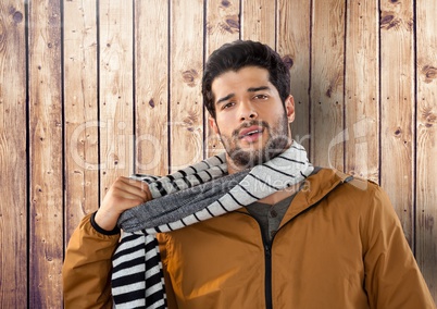Man against wood with warm scarf and coat