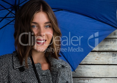 Woman against wood with umbrella and warm coat