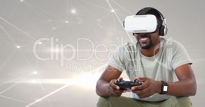man playing with computer game controller with bright light connections in background