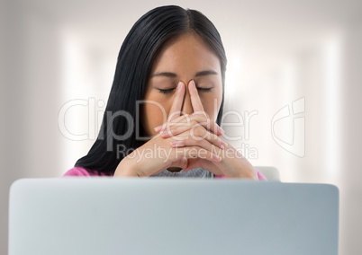 Businesswoman with laptop at desk with bright background