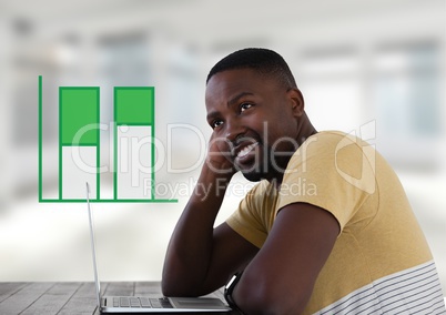 Businessman with laptop at desk with diagrams
