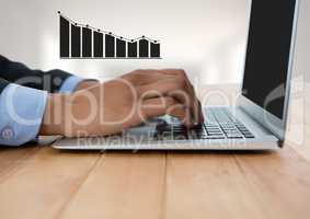 Businessman hands at desk with laptop and bar chart