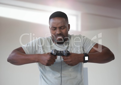 man frustrated playing with computer game controller with bright background