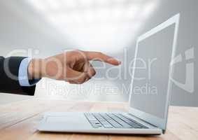 Business hand with laptop at desk with bright background