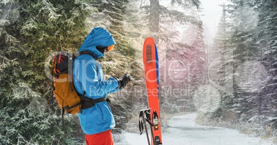 man standing with skies in forrest