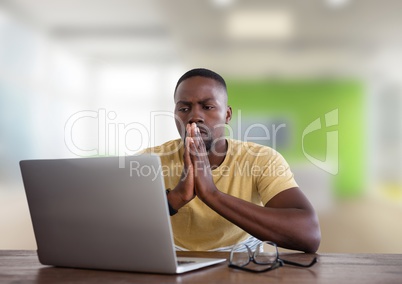 Man at desk with laptop in bright office