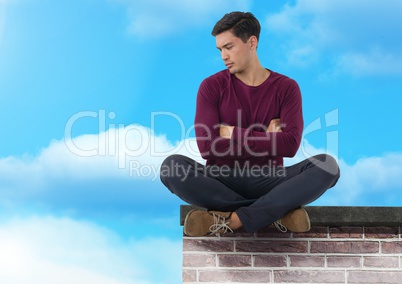Businessman sitting on brick wall