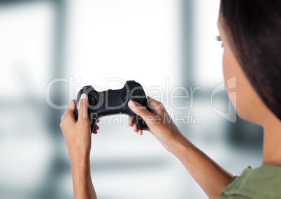 woman playing with computer game controller with bright blurred background
