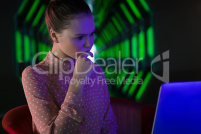 Female executive using laptop in futuristic office