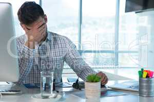 Male executive suffering from headache at desk