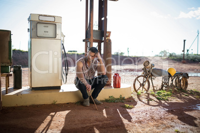 Man sitting at petrol pump station