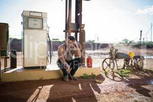 Man sitting at petrol pump station