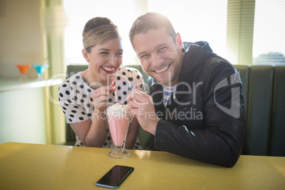 Couple having milkshake in restaurant