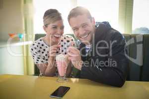 Couple having milkshake in restaurant