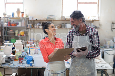 Male and female potter interacting in workshop