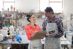 Male and female potter interacting in workshop