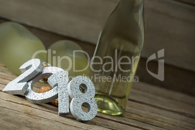 New year number 2018 and champagne bottles arranged on wooden surface
