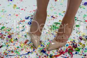 Woman standing wearing beige heels standing on the confetties