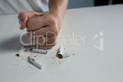 Woman breaking cigarette with fist