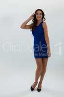 Woman in blue dress posing against white background