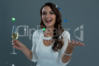 Woman celebrating the New year with falling confetti and champagne