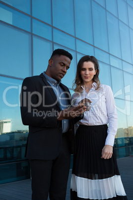 Male and female executive using glass digital tablet