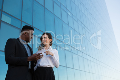 Male and female executive using glass digital tablet