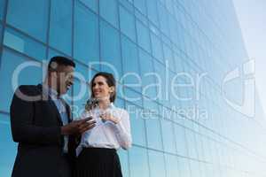 Male and female executive using glass digital tablet