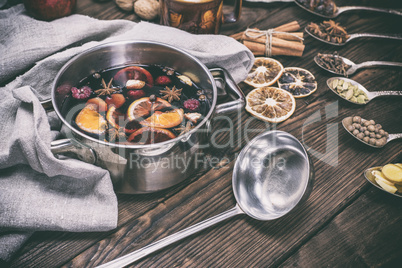 mulled wine in a pot with handles and an iron kitchen scoop