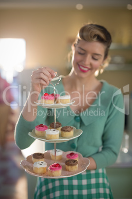 Waitress holding tray of muffins in restaurant