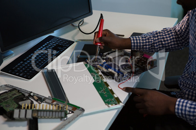 Computer engineer repairing motherboard at desk