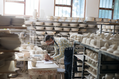 Male potter checking bowl