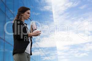 Female executive using glass sheet while having milkshake