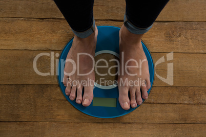 Woman checking her weight on a weighing machine