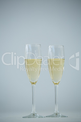 Two champagne flutes against white background