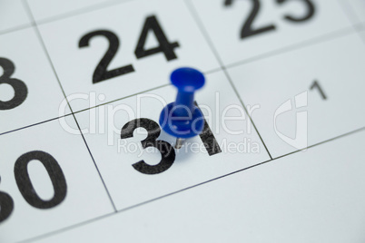 Blue pin push on day 31st of month end on white calendar