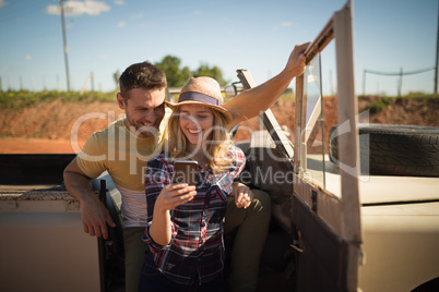 Couple using mobile phone in a car