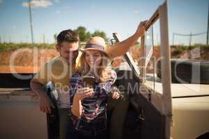 Couple using mobile phone in a car