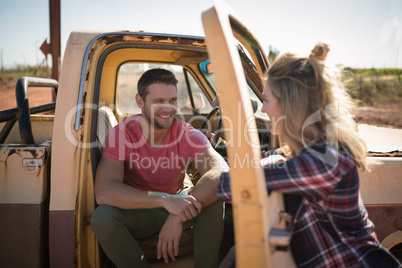 Couple interacting with each other near a car