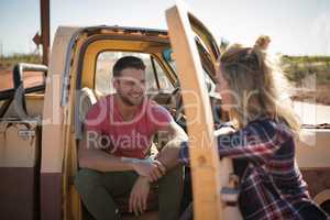 Couple interacting with each other near a car