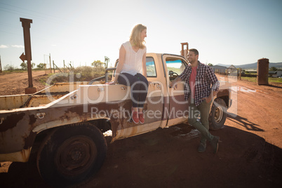 Couple interacting with each other near a car