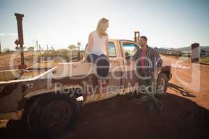 Couple interacting with each other near a car