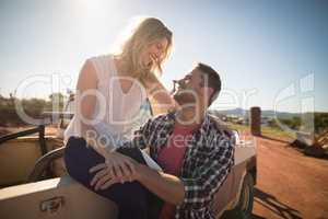 Couple interacting with each other near a car