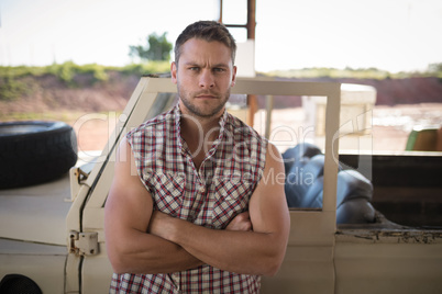 Man standing with arms crossed near his car Man standing with arms crossed near his car