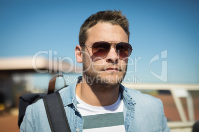 Man in sunglasses standing with his backpack